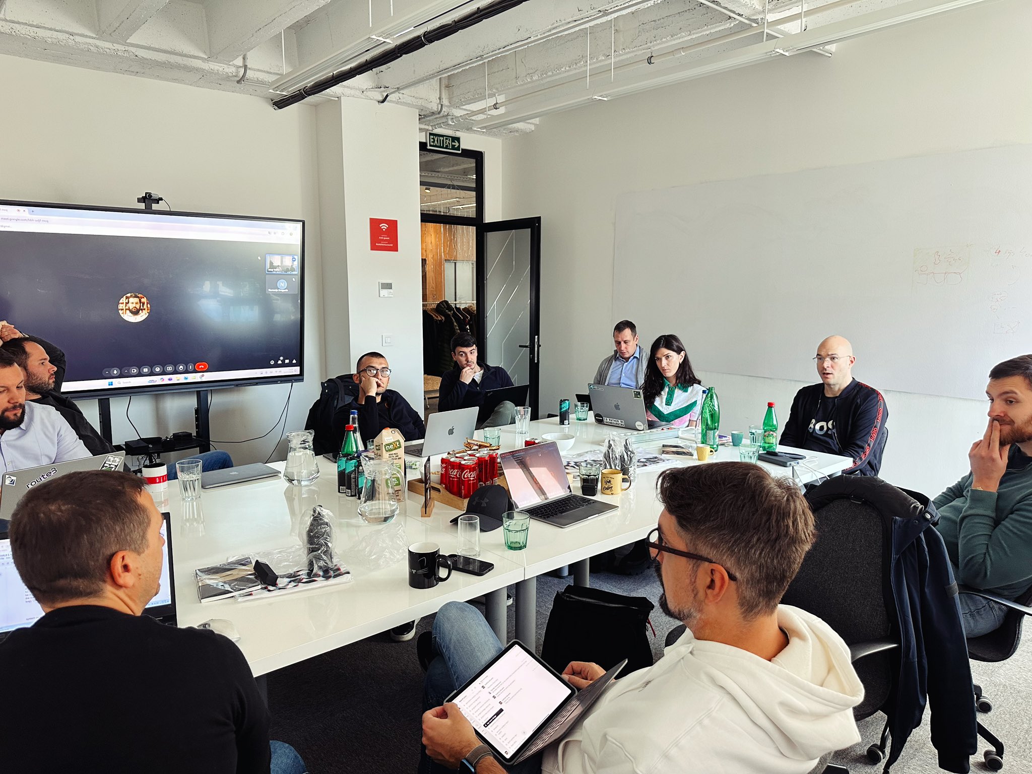 The distributed Apex Fusion team in a discovery workshop around a conference table, with a remote participant on screen.