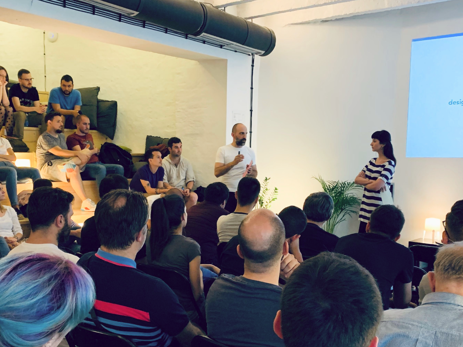 Marija presenting at an IxDA design talk to a seated audience.